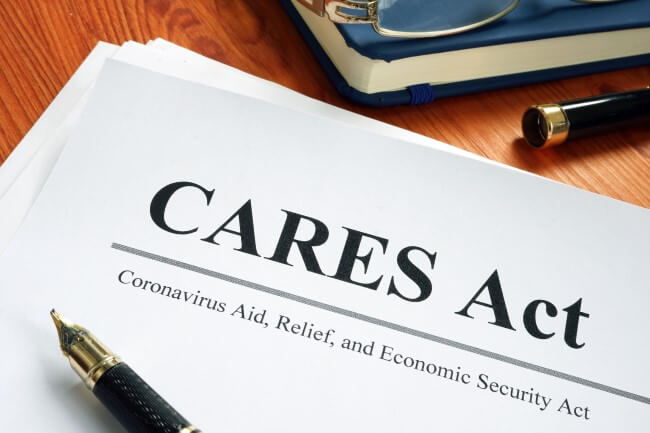 Cares Act with pen resting on top of paper
